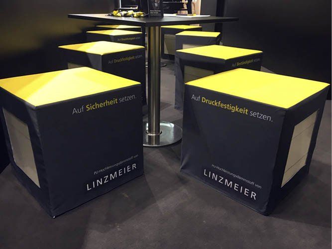 Bedruckte Sitzwürfel auf dem Messestand von Linzmeier Dämmstoffe