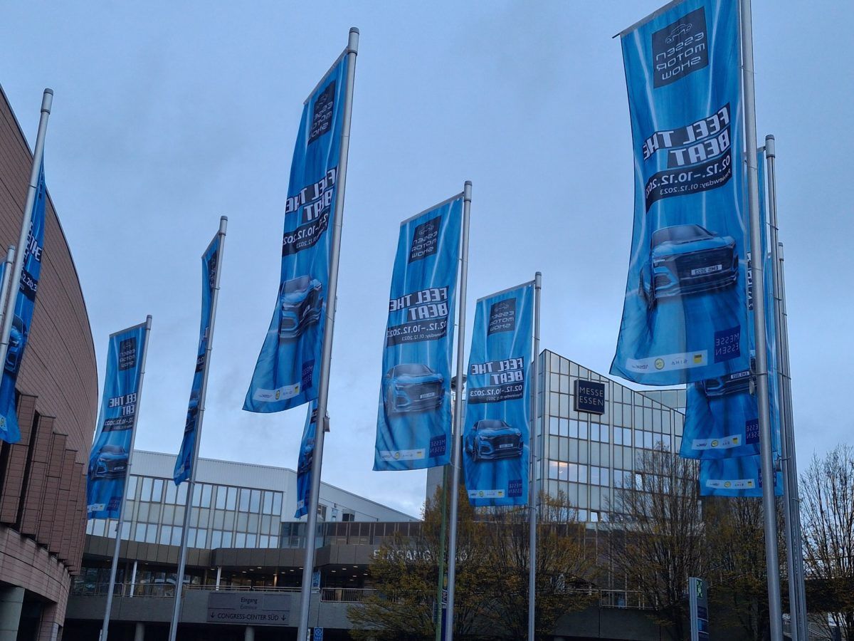 Individuell bedruckte Werbefahnen und Fahnenmasten mit Ausleger vor dem Messe Essen Gebäude