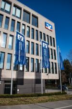 Volksbank Ravensburg mit drei blauen Fahnen auf hohen Fahnenmasten vor der Firmenzentrale